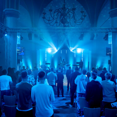 Eine Gruppe von Menschen in der Freien Evangelischen Kirche in Aachen, die sich auf einen inspirierenden Gottesdienst freut.