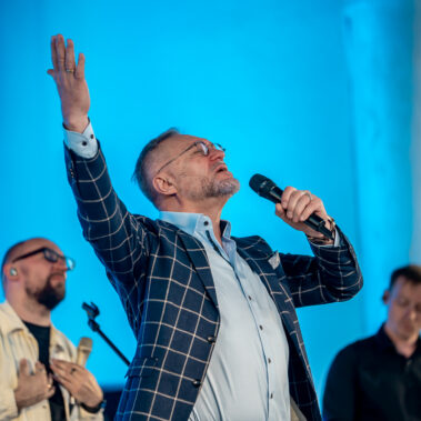 Pastor Viktor Schmidt spricht leidenschaftlich während eines Gottesdienstes bei Neues Leben Aachen. Sein Gesicht strahlt Ruhe und Vertrauen aus.